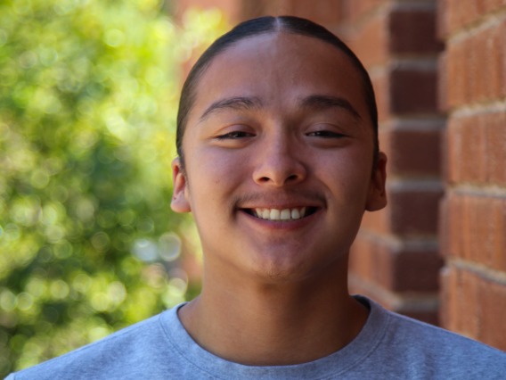 A headshot image of student staff Nicolas Littleman with a brick building in the background
