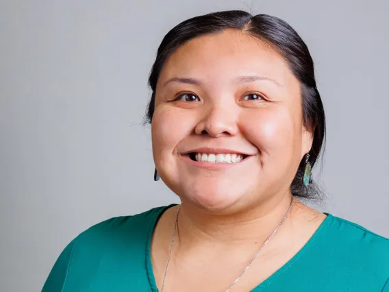 Professional headshot of Myrhea (NASA Coordinator) standing against a gray backdrop