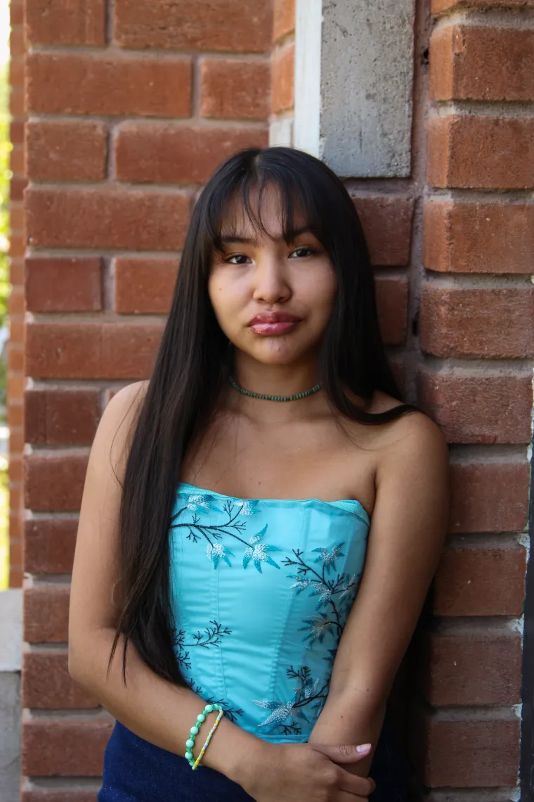 A headshot image of student staff Kelly Haven with a brick building in the background